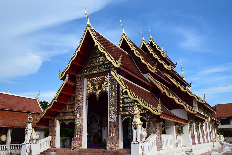วิหารหลังคาซ้อนหลายชั้นประดับลวดลายสีทอง ใต้ท้องฟ้าสีฟ้า